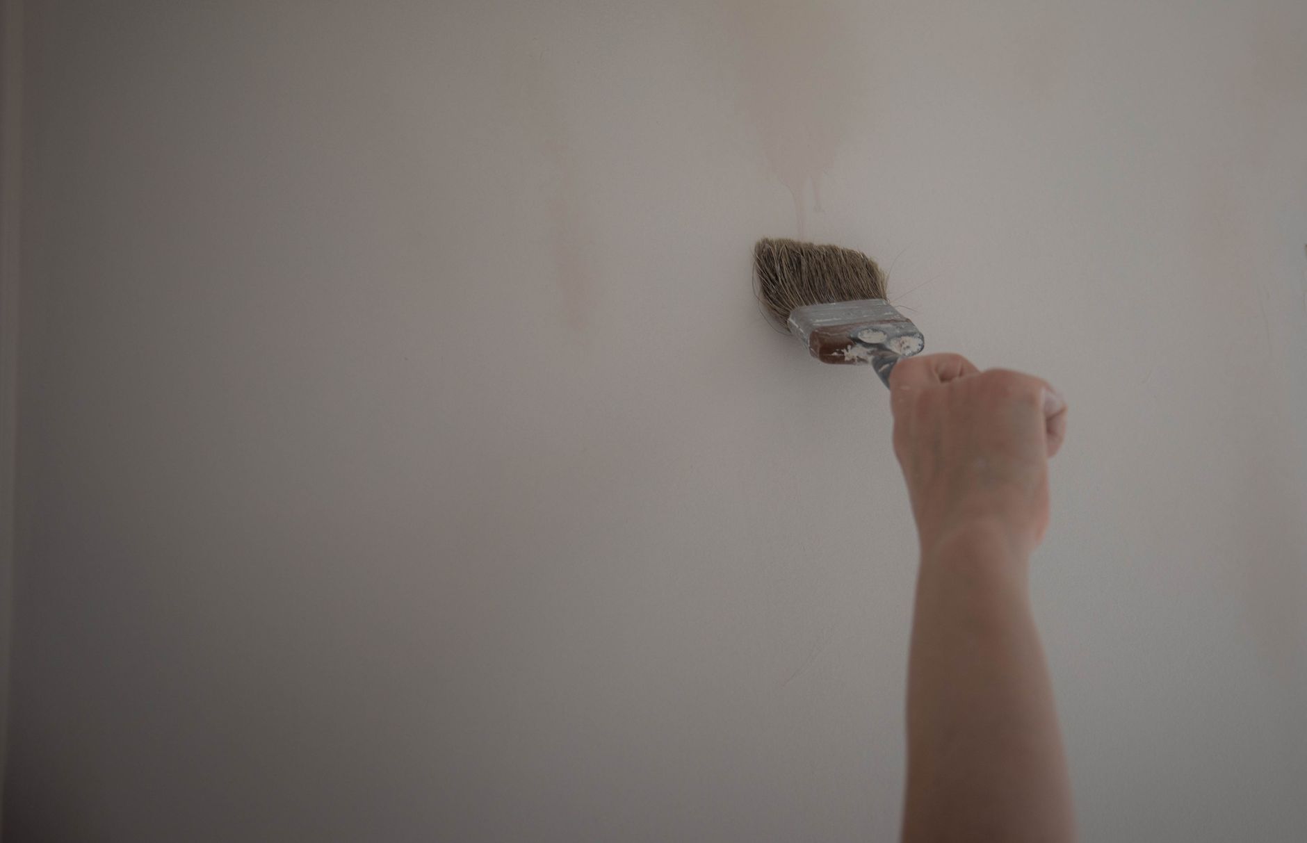 Pinsel streicht eine Wand weiß